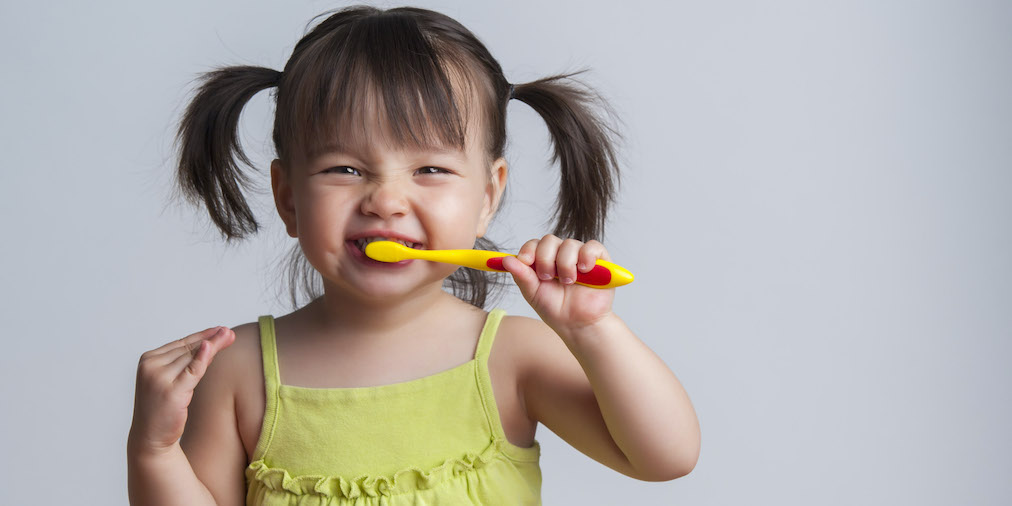 A young child brushing their teeth